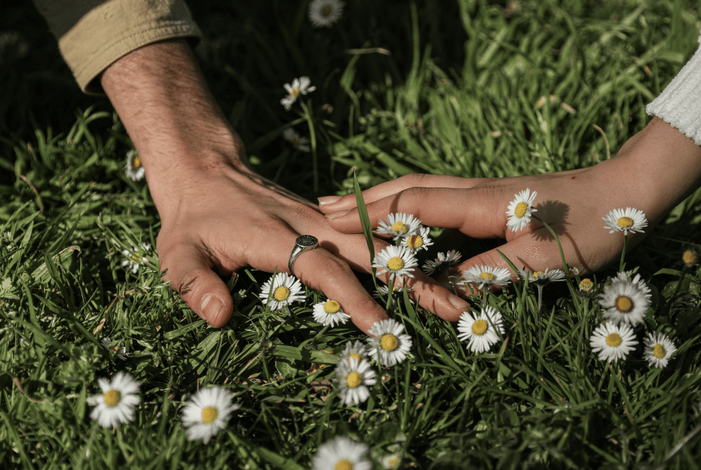 hands holding in spring flowers, love